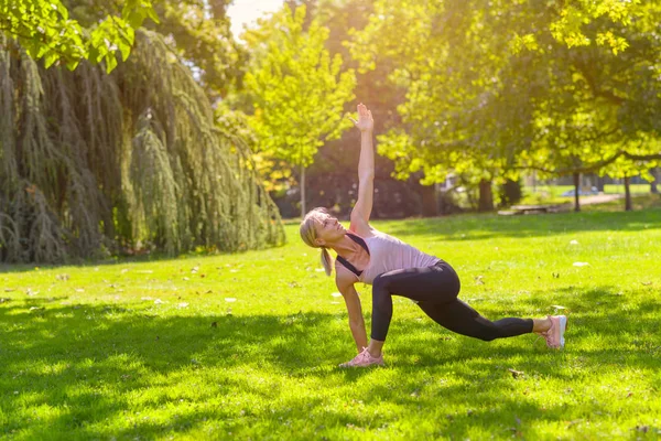 Fit woman doing lunge and stretch exercises — Stock Photo, Image