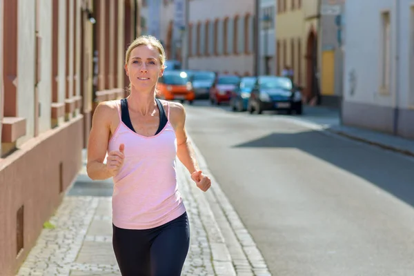 Retrato de una joven en forma corriendo en la ciudad — Foto de Stock