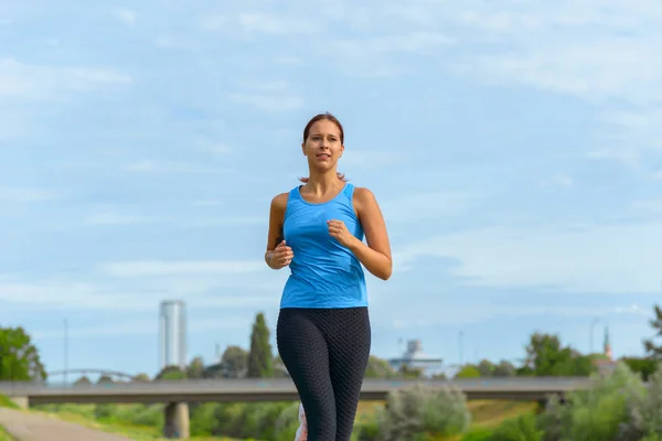 Woman jogging outdoors in summer sunshine