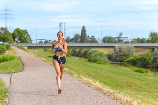 Ajuste mujer atlética corriendo en un camino de campo — Foto de Stock