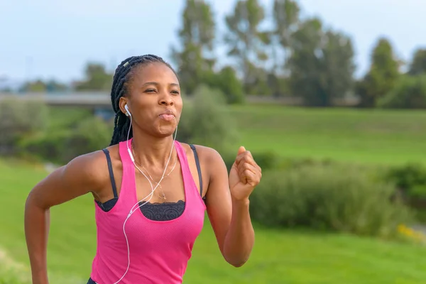 Happy African woman jogging on a rural footpath