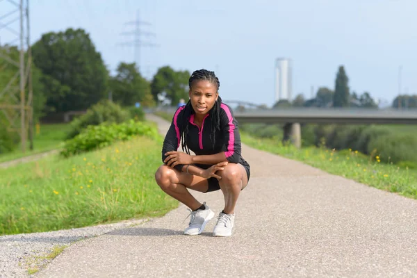 Ajuste deportivo mujer africana agacharse en un camino rural — Foto de Stock