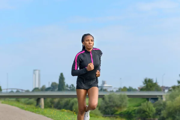 Atlética joven mujer corriendo al aire libre en verano — Foto de Stock