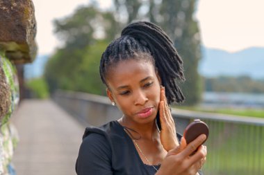 Şık genç Afrikalı kadın yüzünü kontrol