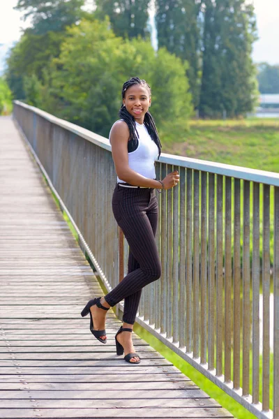 Elegante joven mujer africana de pie en un puente — Foto de Stock
