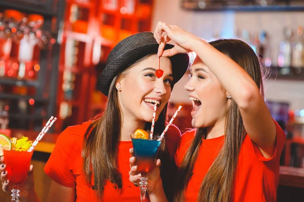在俱乐部的一个聚会上 两个年轻的女同志正在举办鸡尾酒樱桃 — 图库照片