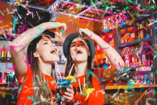 无彩提派对在俱乐部的一个聚会上 两个年轻的女同志正在举办鸡尾酒樱桃 — 图库照片