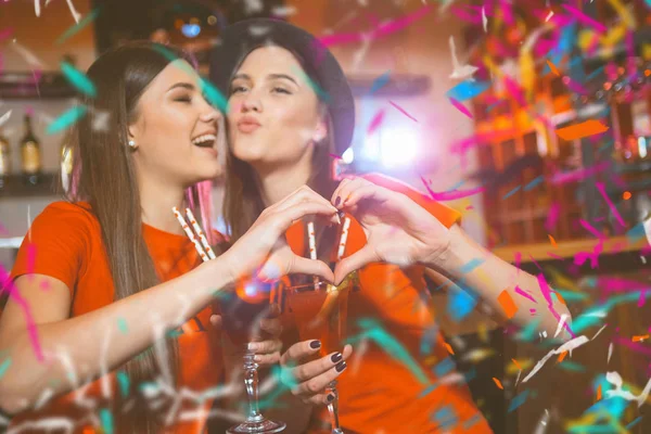 无彩提派对在一次俱乐部聚会上 两个年轻的女同性恋女孩用双手做了一颗心 — 图库照片