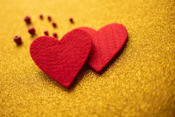 Κόκκινα Τσόχινα καρδιές σε χρυσό γυαλιστερό φόντο. Ημέρα του Αγίου Βαλεντίνου — Φωτογραφία Αρχείου