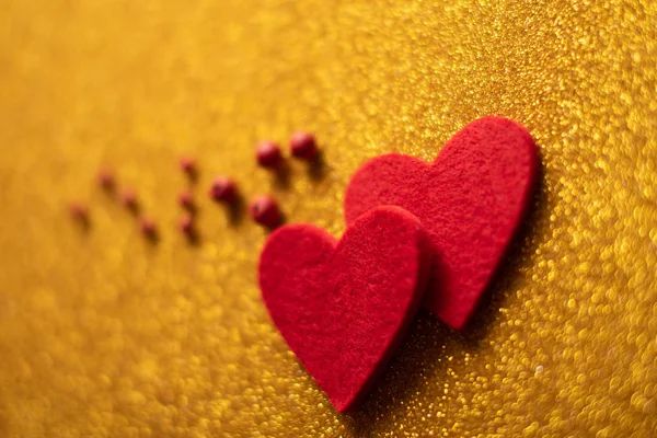 Κόκκινα Τσόχινα καρδιές σε χρυσό γυαλιστερό φόντο. Ημέρα του Αγίου Βαλεντίνου — Φωτογραφία Αρχείου