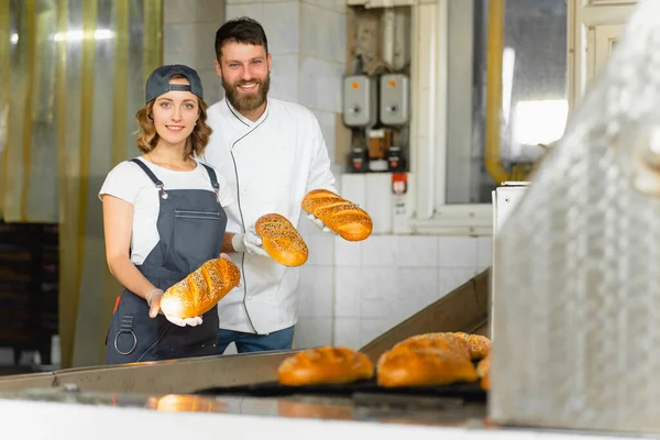 Дівчина Чоловік Пекарі Хлібом Руках Тлі Промислової Печі Пекарні Виробництво — стокове фото