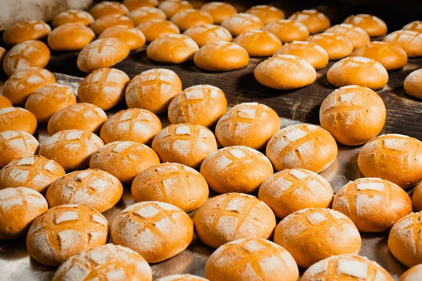 Fırındaki fırın. Sıcak taze ekmek endüstriyel fırını bir fırında bırakır. Otomatik ekmek üretim hattı