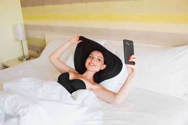 Ung Flicka Stor Hatt Gör Selfie Smartphone När Ligger Sängen — Stockfoto