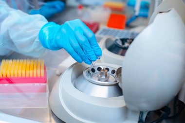 Laboratuvarda DNA testi. Elinde şeker kutusuyla laboratuvar teknisyeni steril bir laboratuvarda cam arkasında DNA analizi yapıyor..