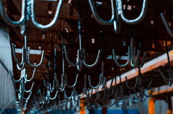 Steel hooks in the galvanizing plant. Metallurgical plant. Texture of metal. Metal industry. Background