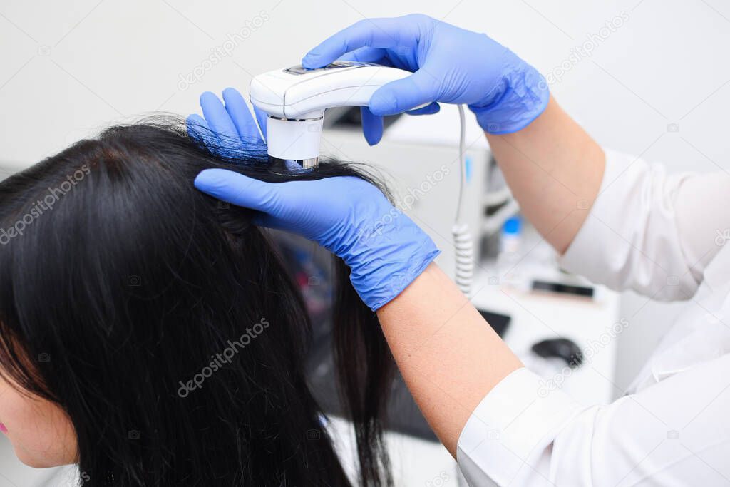 Trichoscopy of the scalp in a medical cosmetology center. Scalp hair treatment.