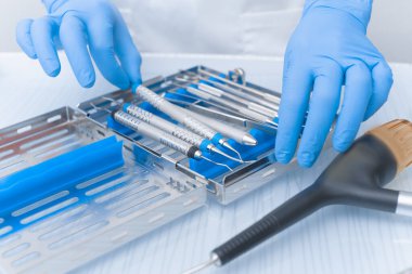 Diş aletleri yakın plan bir doktorun elinde. Diş Hekimi Konsepti.