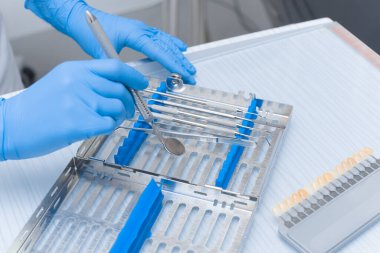 Diş aletleri yakın plan bir doktorun elinde. Diş Hekimi Konsepti.