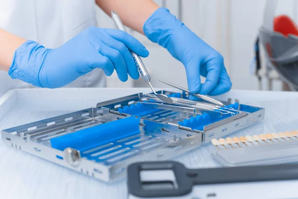 Diş aletleri yakın plan bir doktorun elinde. Diş Hekimi Konsepti.