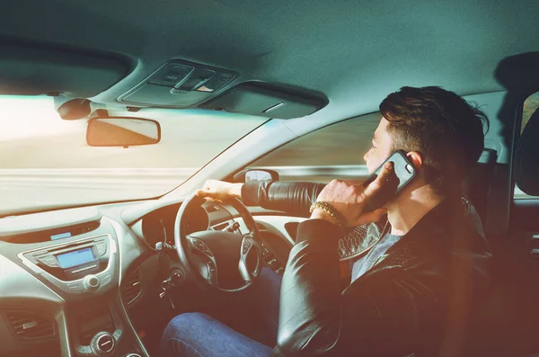 A man talking on a mobile phone in a car at high speed. Driving at high speed. Car travel.