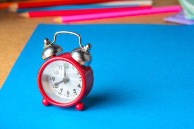 Okul konseptine geri dönelim. Mavi arka planda eski bir kırmızı çalar saat. Boşluğu kopyala.