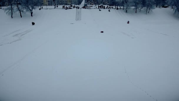 Kinder laufen einen Schneehügel hinunter
