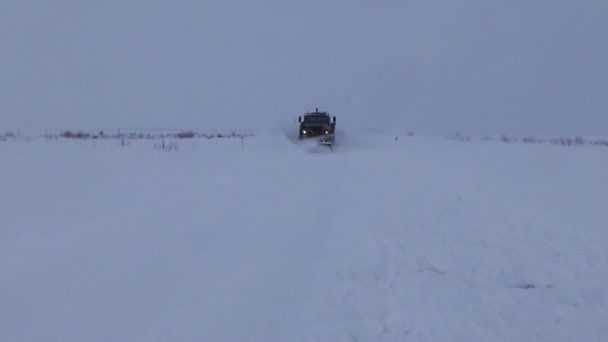 El coche quita la nieve de la carretera — Vídeos de Stock