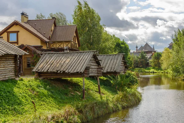 Old wooden houses on the river bank in summer.