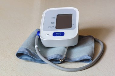 Ahşap bir masa beyaz elektronik tonometer yakın çekim. Kan basıncı ölçümü. Sağlıklı kavramı.