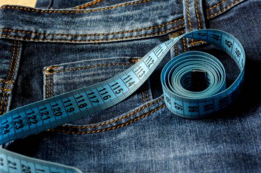 Mavi jeans ve teyp yakın çekim ölçme bir mavi. Ölçüm boyutu. Diyet ve sağlıklı.