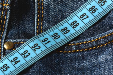 Mavi jeans ve teyp yakın çekim ölçme bir mavi. Ölçüm boyutu. Diyet ve sağlıklı.
