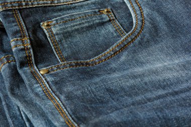 Mavi jeans turuncu dikiş ile bir parça Close-up. Perçin yakın çekim ile cep.