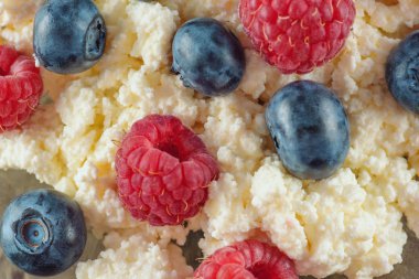 Taze ahududu ve yaban mersini olgun çilek ile sağlıklı bir kahvaltı için süzme peynir. Arka plan doğal sağlıklı bir üründür.