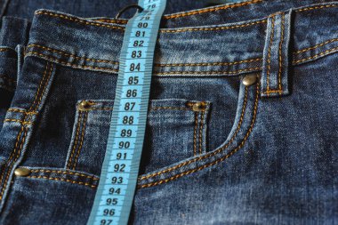 Mavi jeans ve teyp yakın çekim ölçme bir mavi. Ölçüm boyutu. Diyet ve sağlıklı.