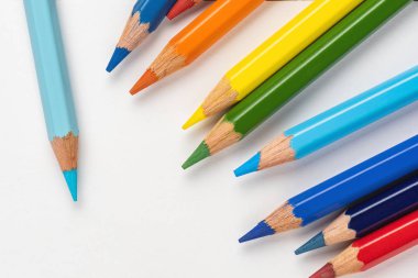 Beyaz bir arka plan üzerinde dağınık çizim için renkli kalemler. Gökkuşağının renkleri.