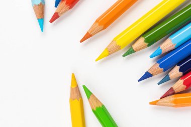 Beyaz bir arka plan üzerinde dağınık çizim için renkli kalemler. Gökkuşağının renkleri.