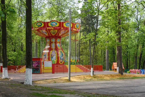 Parkta yaz aylarında çocukların cazibe atlıkarınca. Boş zaman, çocuklar için oyunlar. Mutluluk.