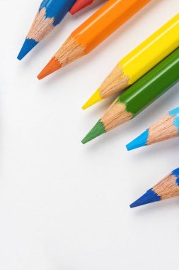 Beyaz bir arka plan üzerinde dağınık çizim için renkli kalemler. Gökkuşağının renkleri.