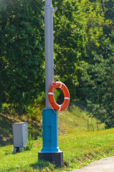 Orange Lifebuoy Hanging Rope Metal Pole Background Trees — Stock Photo, Image