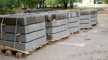 Kaldırım taşı bir palet üzerinde yatıyor. Kaldırım taşı yol rement için hazırlanmıştır.