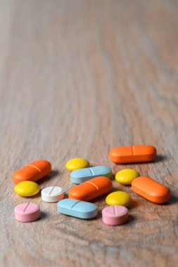 Masanın üzerine çeşitli renkli tabletler yakın plan. Koronavirüs enfeksiyonunun korunma ve tedavisi kavramı. Boşluğu kopyala.