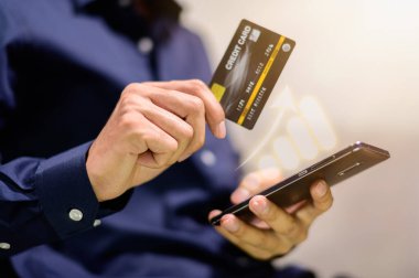 İş adamları akıllı telefonlarında grafik tabloları gösterip kredi kartı kullanıyorlar.
