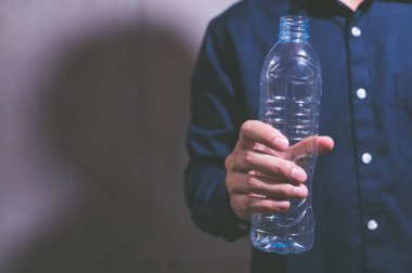 Bir iş adamının elinde boş bir plastik su şişesi olması fikri...