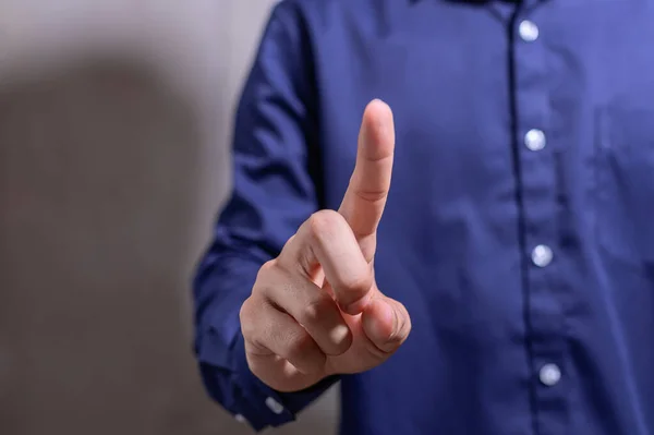 A business man pointing a finger in a blue shirt
