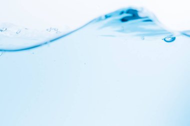 Mavi su dalgalarının yüzeyi beyaz bir zemine vuruyor.