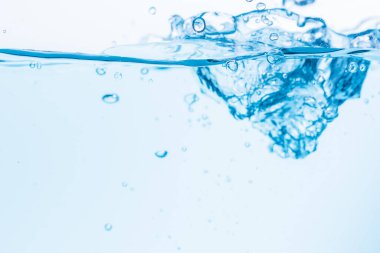 Mavi su dalgalarının yüzeyi beyaz bir zemine vuruyor.