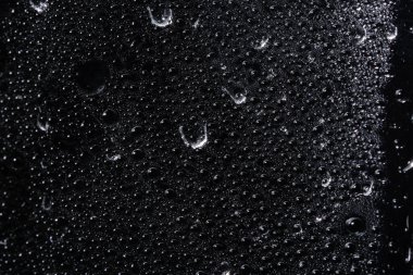 Şeffaf plastik tabaka üzerinde makro damlası, siyah arkaplan