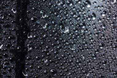 Şeffaf plastik tabaka üzerinde makro damlası, siyah arkaplan