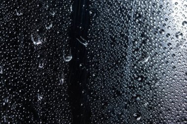 Şeffaf plastik tabaka üzerinde makro damlası, siyah arkaplan