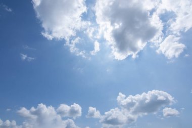 Güneş, mavi gökyüzü ve bulutlar.